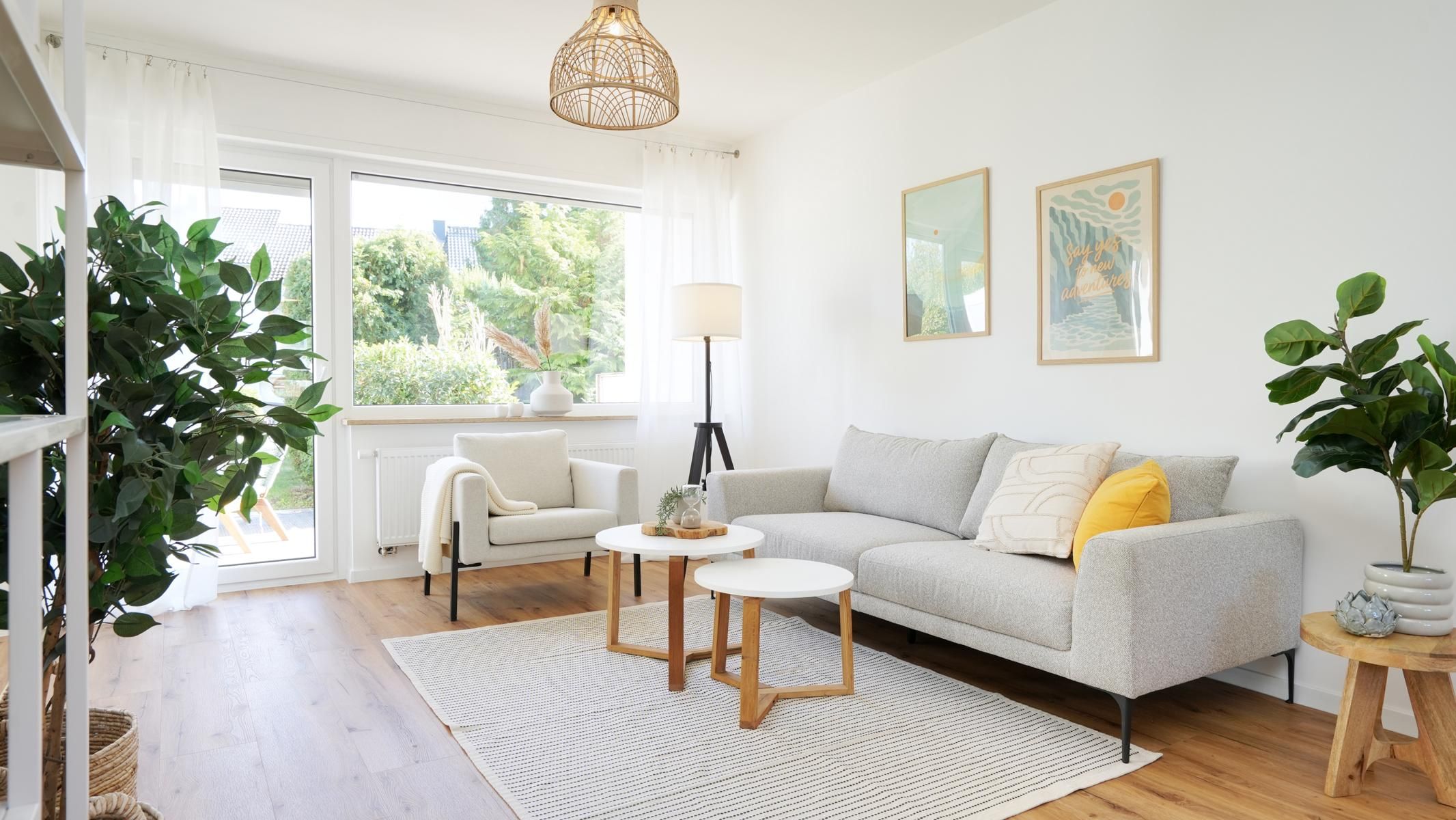 Helles Wohnzimmer mit Sofa und großem Fenster zum Garten